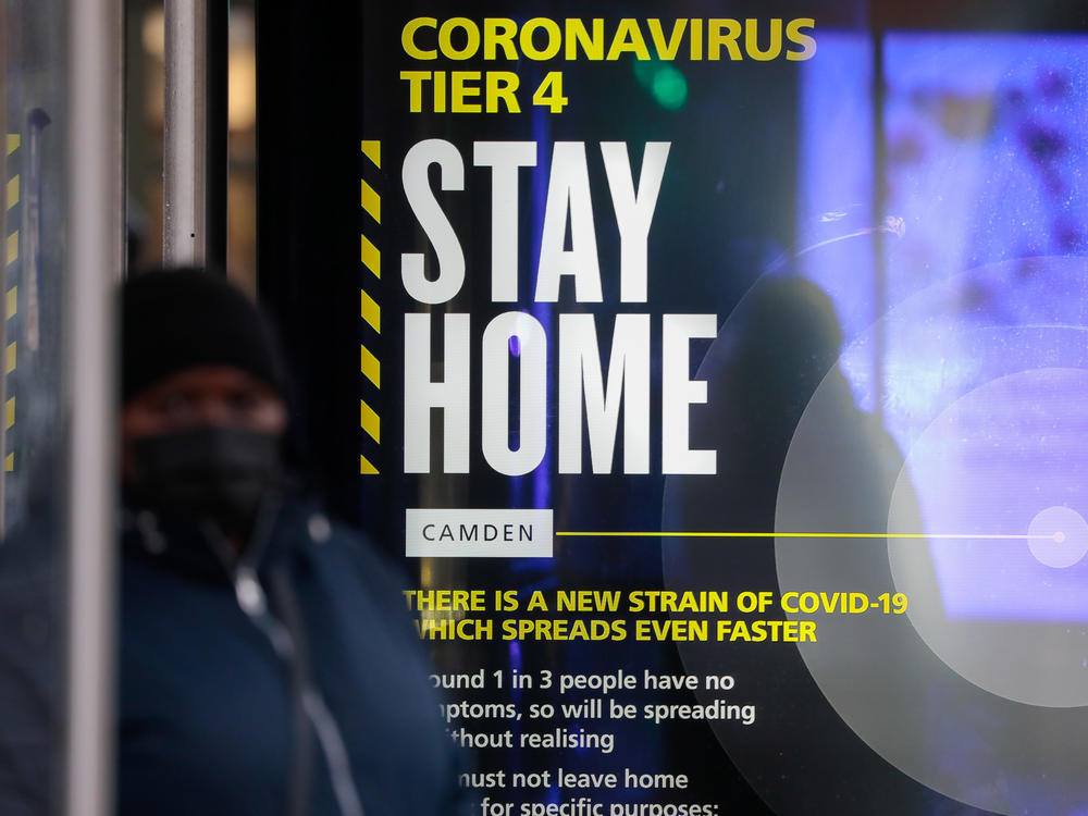A poster about the new, fast-spreading variant of the coronavirus warns some Britons to stay home. The sign is displayed near King's Cross railway station in London.