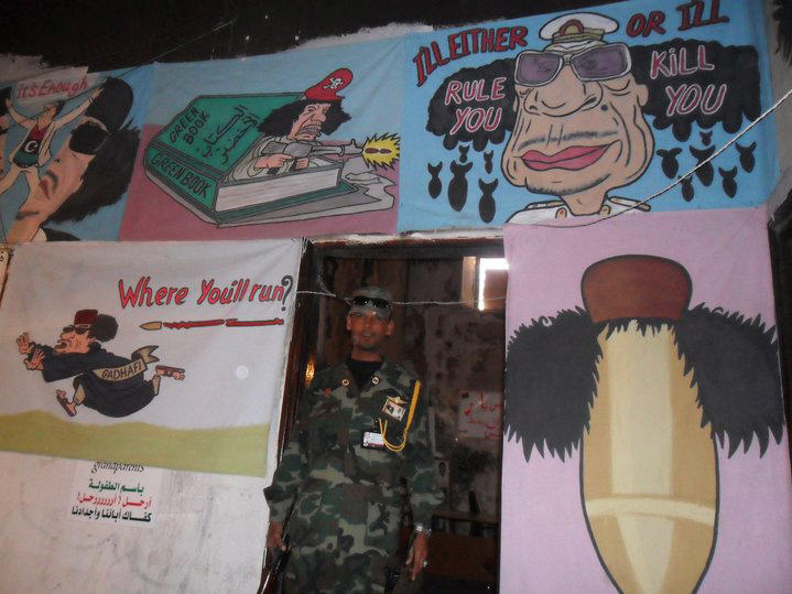 A soldier stands near anti-Gadhafi graffiti in Libya in 2011. The revolution that ousted Libya's longtime leader later that year resulted in a cycle of tribal and factional infighting, and a civil war that has essentially divided the country.