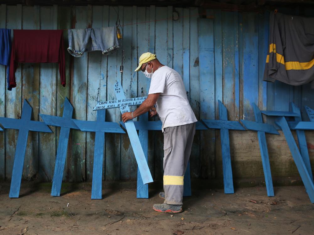 Ulisses Xavier, 52, who has worked for 16 years at Nossa Senhora cemetery in Manaus, Brazil, makes wooden crosses to supplement his income. The cemetery has seen a surge in the number of new graves after the outbreak of COVID-19.