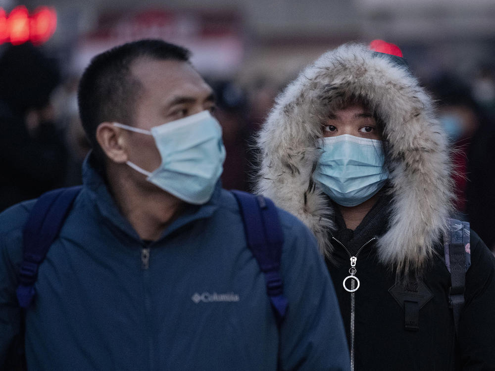 Chinese travelers at a railway station in Beijing, China, wear face masks to protect themselves from the new coronavirus on Jan. 21, 2020. The virus was first identified in Wuhan, China, in Dec. 2019, and since then has quickly spread worldwide.