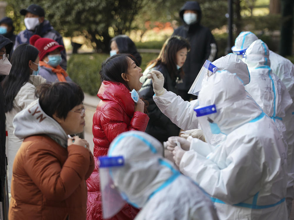 In this photo released by Xinhua News Agency, medical workers take swabs from residents in Shijiazhuang in north China's Hebei province on Jan. 6. Authorities have announced new restrictions to contain the coronavirus.