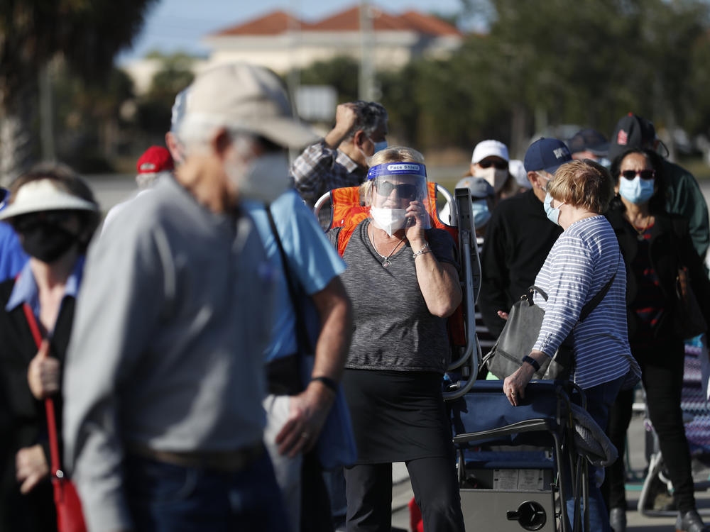 Older adults and first responders wait in line to receive a COVID-19 vaccine late last month at the Lakes Regional Library in Fort Myers, Fla.