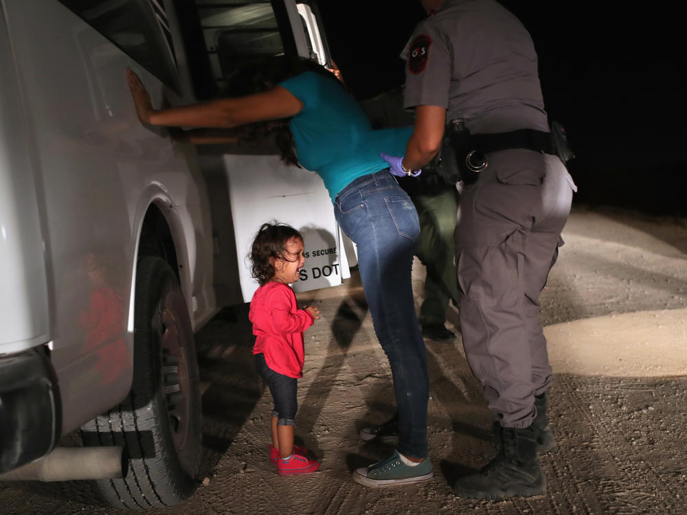 A child cries as her mother is searched near the U.S.-Mexico border in June 2018. During the two and a half months the policy was in place, more than 3,000 children were separated from their families.