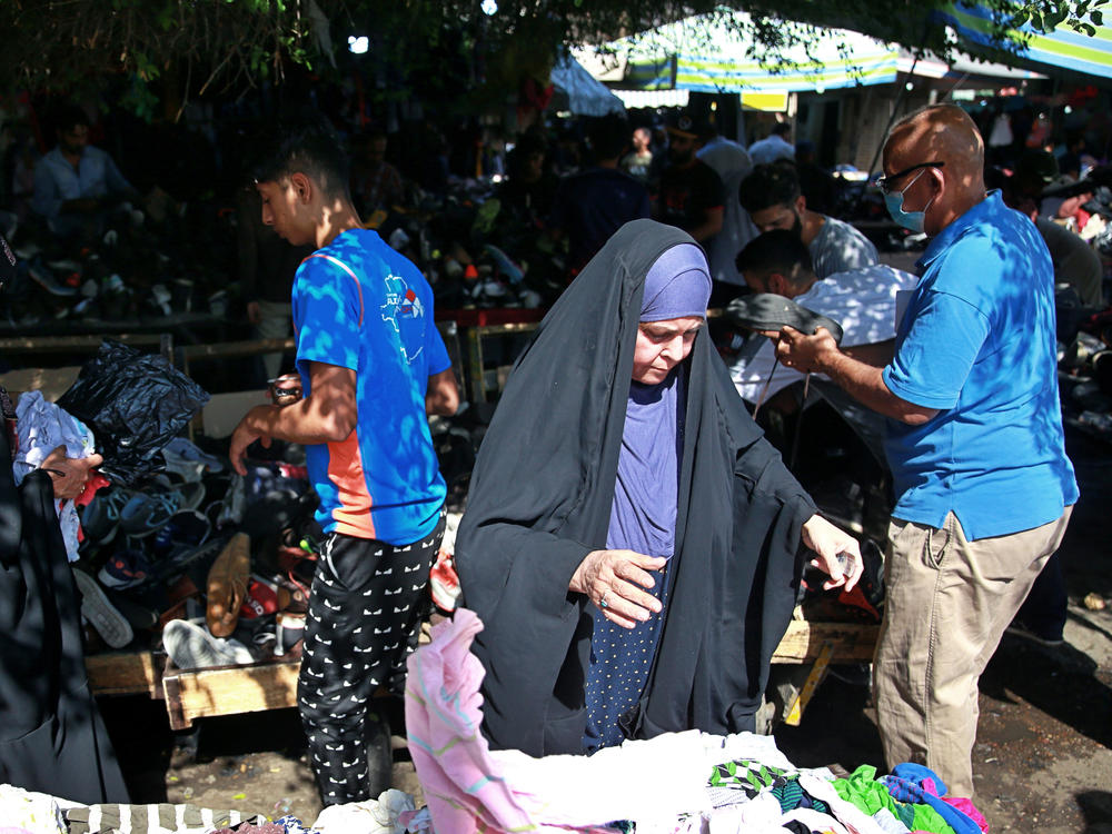 People shop in October for used clothes at the Baghdad market selling them.