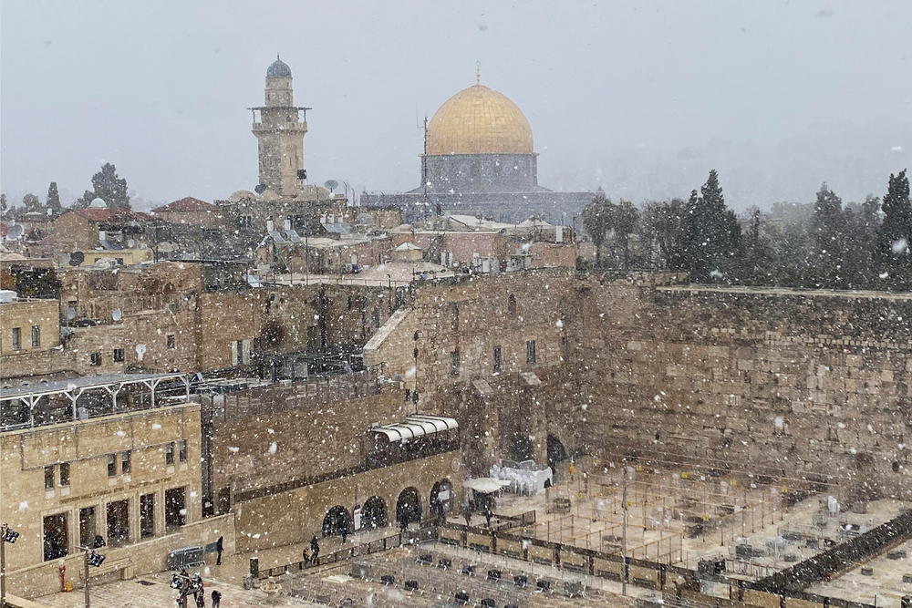 A general view of Jerusalem's Old City shows the Western Wall in the foreground and the Dome of the Rock in the background, as the snow starts to fall in Jerusalem on Wednesday.