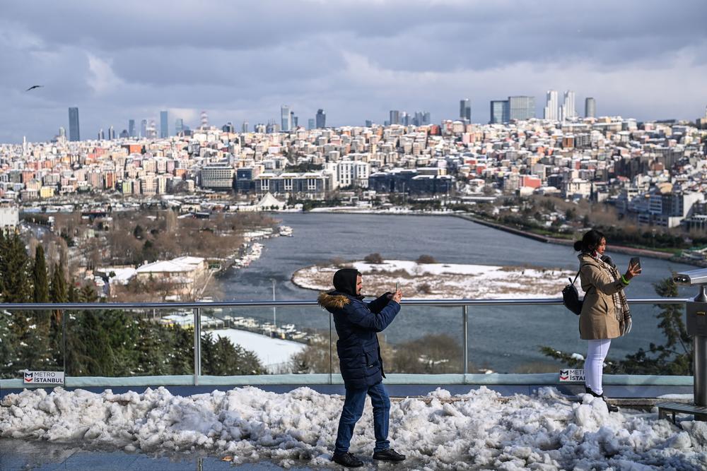 People take pictures at the Pierre Loti Hill near the Eyup Sultan district in Istanbul after a heavy snowfall, on Tuesday.