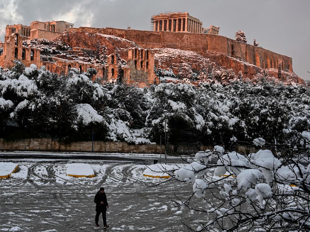 The setting sun illuminates the ancient Acropolis in Athens, Greece, after a rare heavy snowfall in the city on Tuesday.
