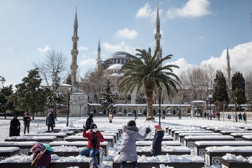 Children throw snowballs in front of the Blue Mosque on Wednesday in Istanbul. An overnight cold front brought heavy snowfall to Istanbul in the early morning, blanketing the city, delaying morning commutes and disrupting ferry services.