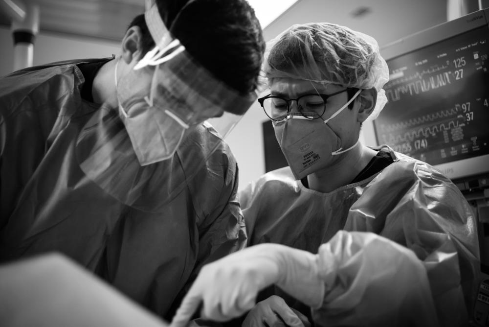 Dr. Nhu-Nguyen Le (right) supervises Dr. Chase Luther during a procedure.