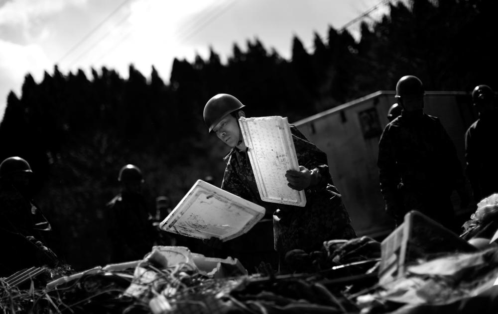Japanese Defense Force soldiers help to remove the remains of a fishing market near the town of Noda, in northeastern Japan, March 18, 2011.