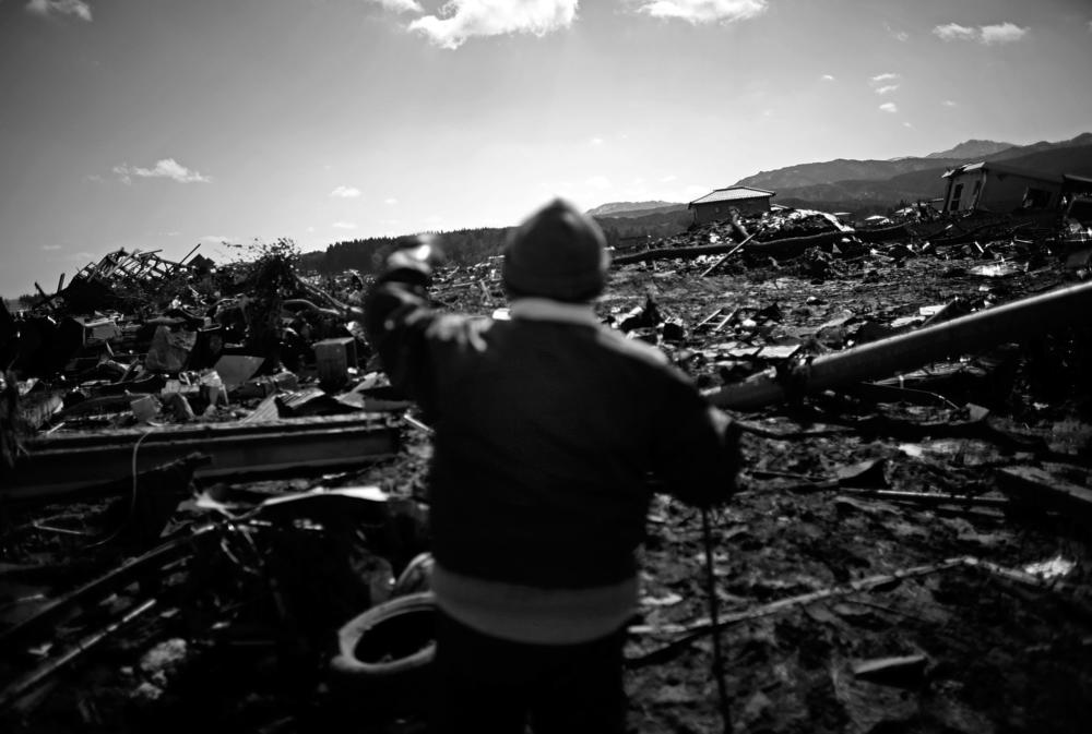 A elderly man looks out over the shattered landscape of the coastal town of Noda, Iwate Prefecture, in northeastern Japan, on March 18, 2011.