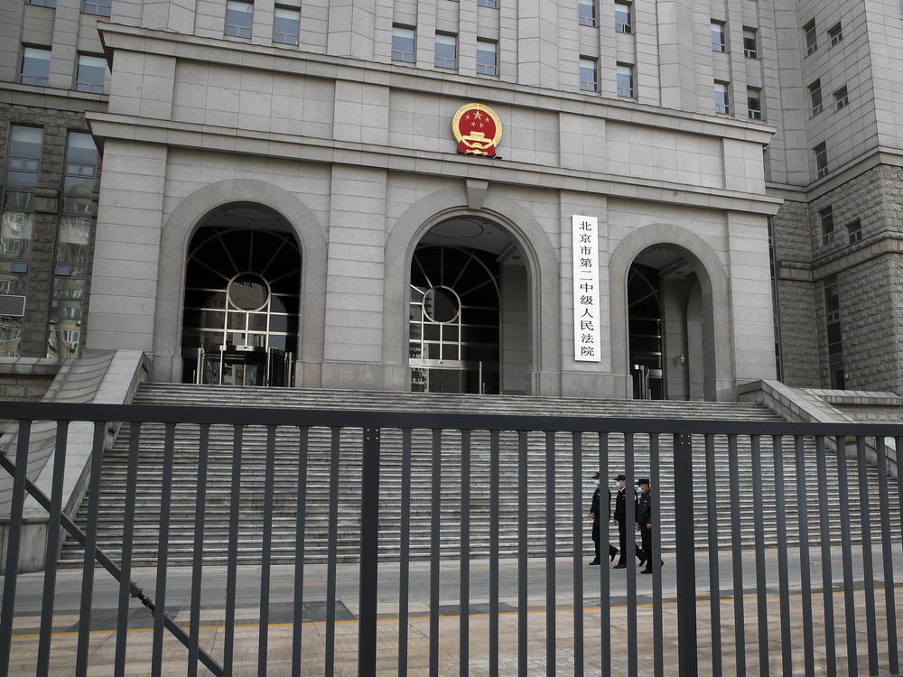 Policemen wearing face masks patrol at the compound of No. 2 Intermediate People's Court in Beijing on Monday, as Canadian Michael Kovrig went on trial in a closed courtroom for espionage.