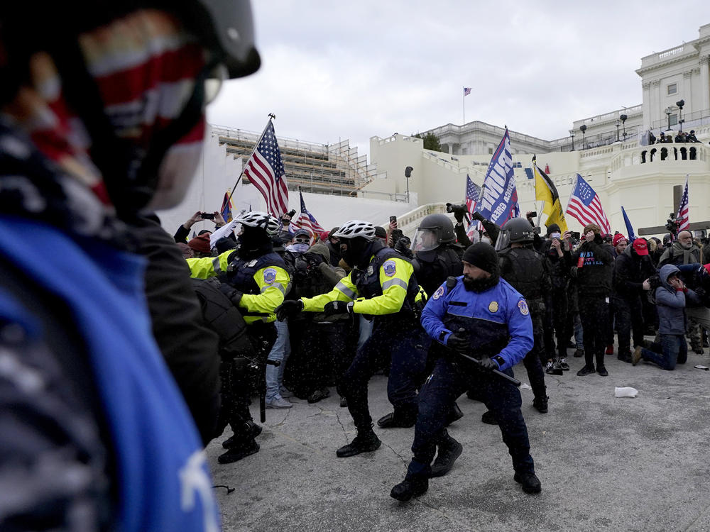 Police officers try to push back President Donald Trump supporters trying to break through a police barrier, Jan. 6 at the Capitol in Washington. Two U.S. Capitol police officers have sued Trump for allegedly inciting the mob that attacked them that day.
