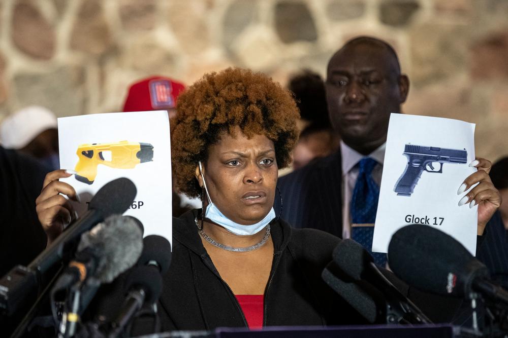 Naisha Wright, Daunte Wright's aunt, holds up pictures of a Taser and a handgun Thursday in Minneapolis. She questioned how the ex-police officer charged in her nephew's death could have mixed up the two.