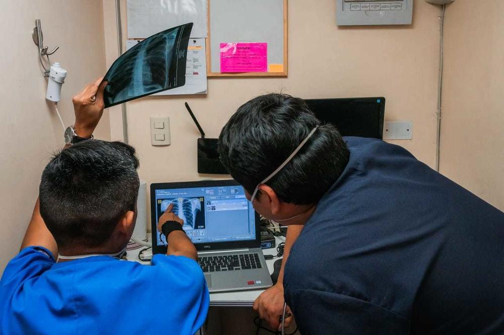 TB Móvil employees examine chest X-rays for signs of abnormalities in the lungs. In Lima, two vans are equipped with AI-enhanced computers that use deep learning to create a heat map of suspicious areas and score the X-ray for likelihood of infection.