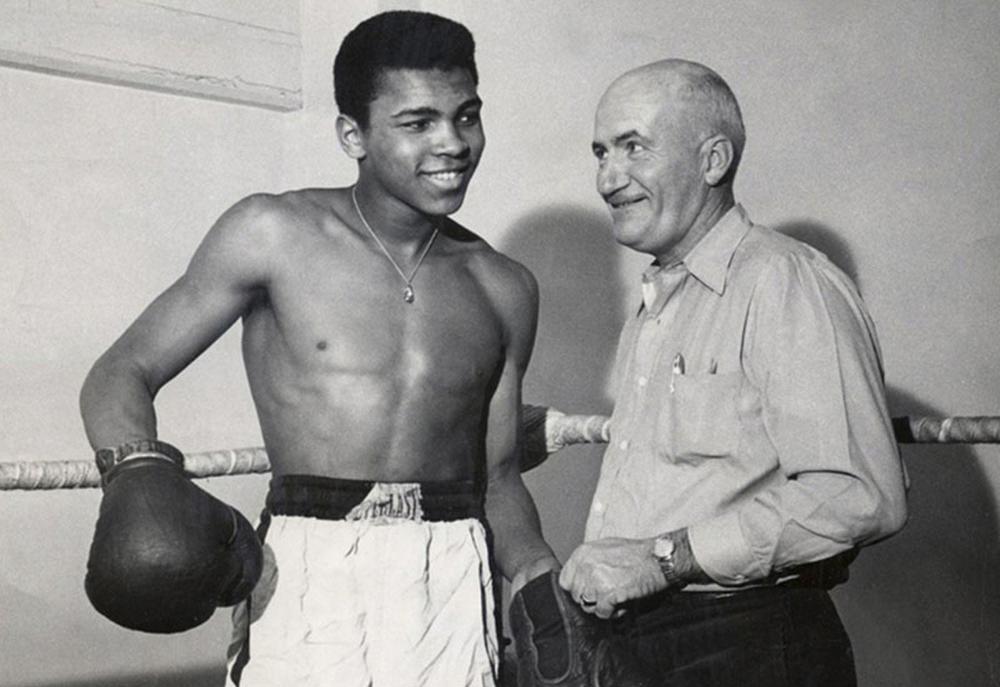 A young Muhammad Ali, then Cassius Clay, in 1960 with his trainer Joe Martin. Ali got his start on <em data-stringify-type=