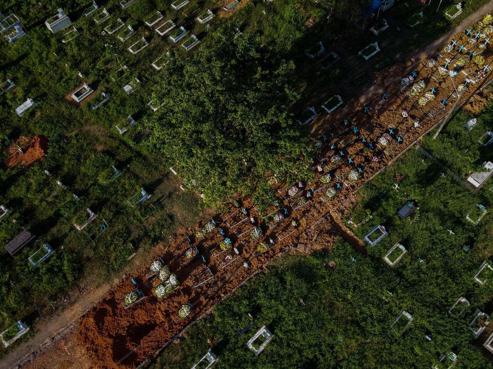 With little space left at Nossa Senhora Aparecida cemetery in Manaus, Brazil, graves of COVID-19 victims line a street, seen in an aerial photo taken on Thursday as the country passed 400,000 virus deaths.