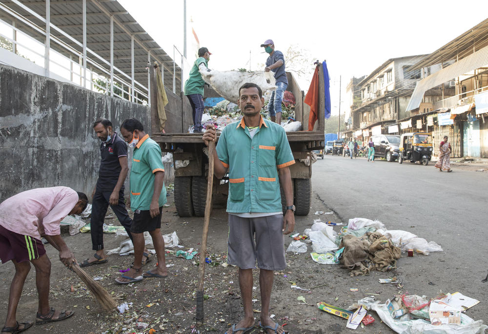 Sanitation worker Ramesh Solanki cleans the streets outside India's Palghar railway station. 