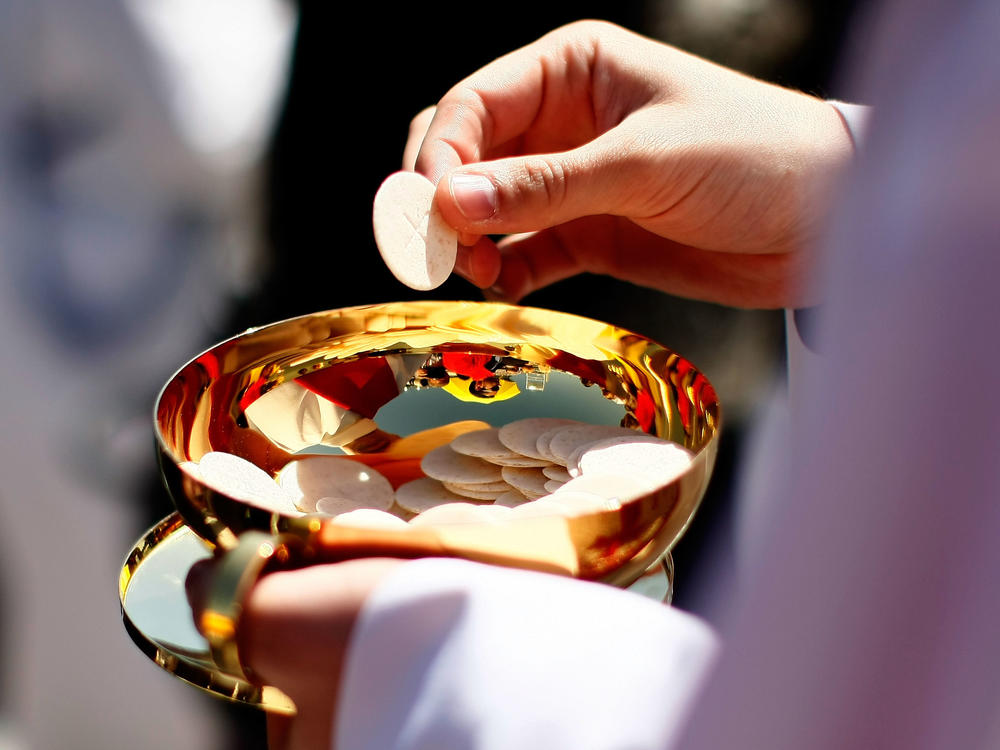 A priest holds a Holy Communion wafer in Washington, D.C.