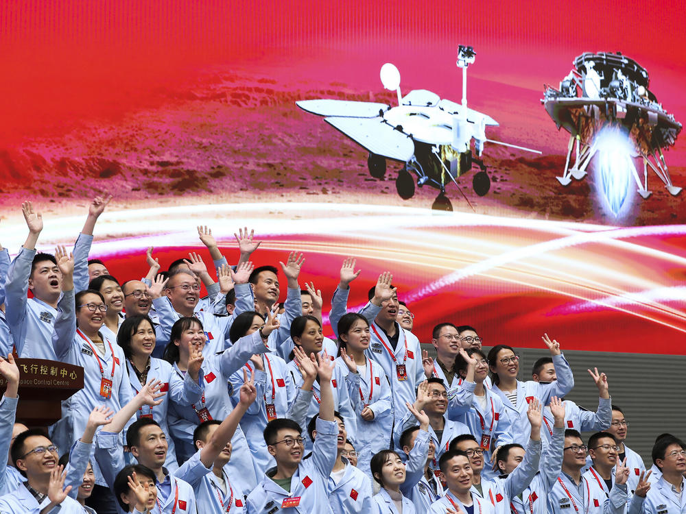 In this photo released by Xinhua News Agency, members at the Beijing Aerospace Control Center celebrate after China's Tianwen-1 probe successfully landed on Mars, at the center in Beijing, Saturday, May 15, 2021.