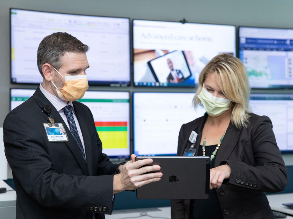 Dr. Michael Maniaci and Dr. Margaret Paulson confer at the Mayo Clinic's hospital-at-home command center in Jacksonville, Florida.