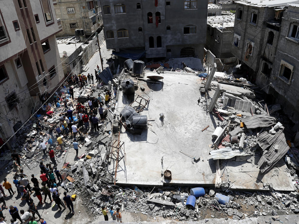 People gather near the rubble of a residential building hit by Israeli airstrikes Thursday in Beit Lahiya, Gaza Strip.