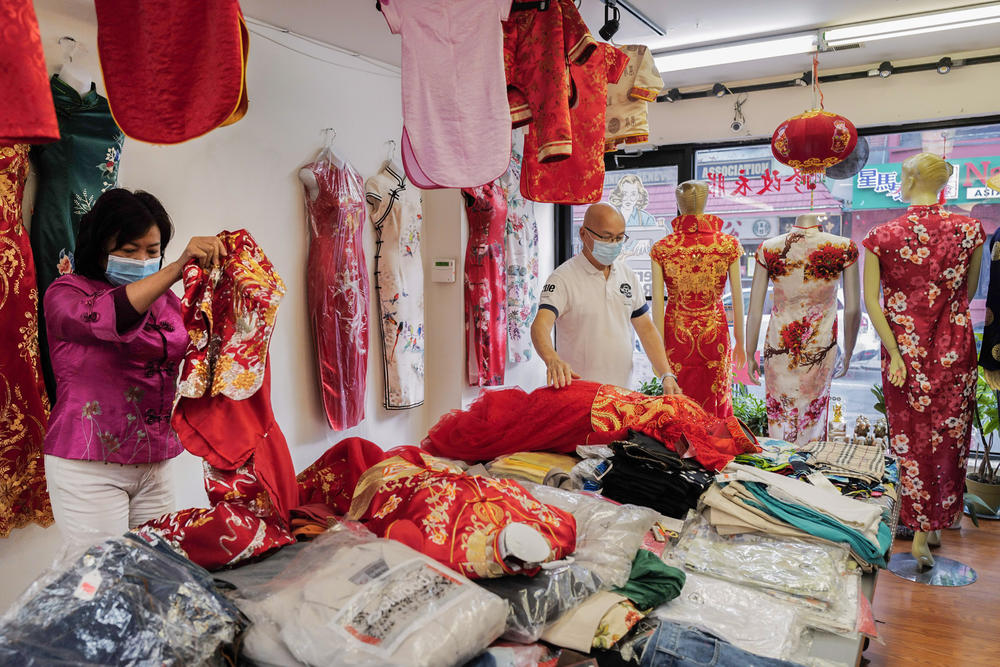 In 2000, when Lai saw better housing options in Philadelphia, she decided to move there, founding Dia Boutique, a shop in Chinatown that sells cheongsams and provides alteration services. Here, the couple arrange the cheongsams in the shop.