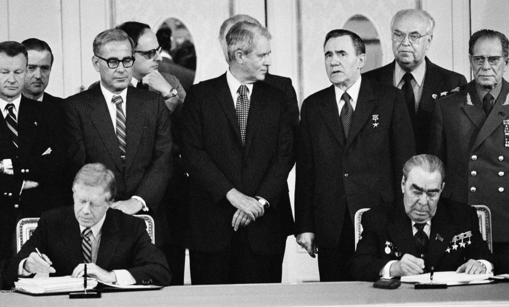 President Jimmy Carter (seated left) and Soviet President Leonid Brezhnev (seated right) sign the SALT II treaty on June 18, 1979, in Vienna, Austria.