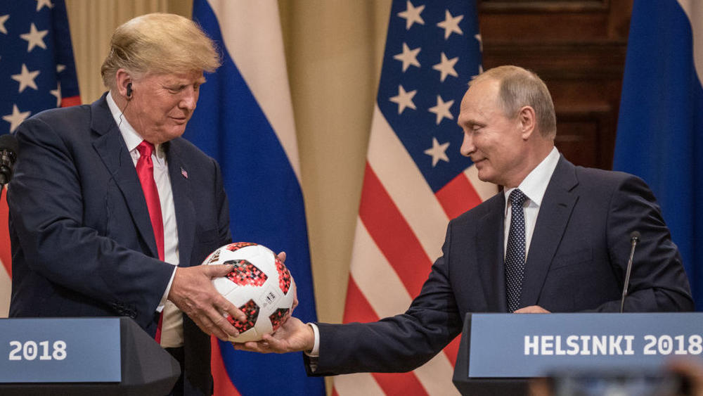 Russian President Vladimir Putin hands President Donald Trump a World Cup football during a joint press conference after their summit on July 16, 2018, in Helsinki, Finland.