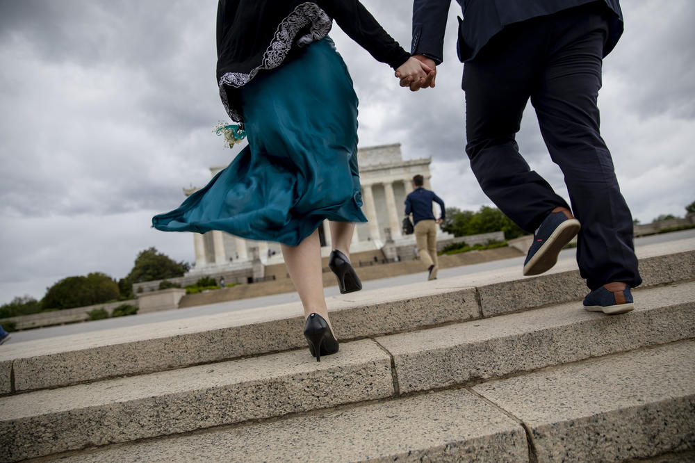 Nellie Trnkus, 18, who is graduating from Bethesda Chevy Chase High School in Maryland, and Ahmed Mohmad, who attends Montgomery College, head to the Lincoln Memorial for prom photos. They said they were more comfortable getting together in a small group to celebrate now that vaccines are readily available and rates of infections are going down.