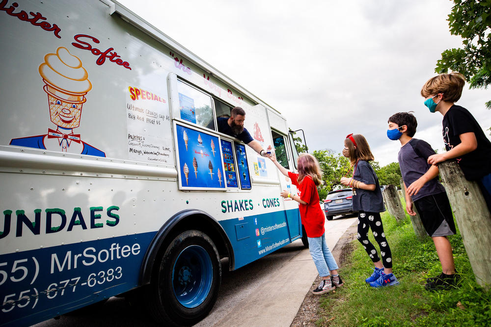 Jeff Rollins with the Mister Softee ice cream truck serves students and families from the Cherrywood neighborhood of Austin, Texas, as they celebrate graduating fifth-graders from Maplewood Elementary School on June 2. <a href=