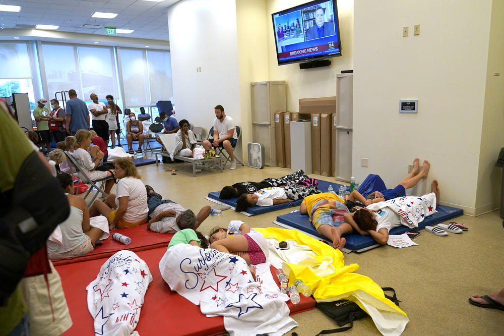 People lie on cots as they wait for news at the family reunification center on Thursday.