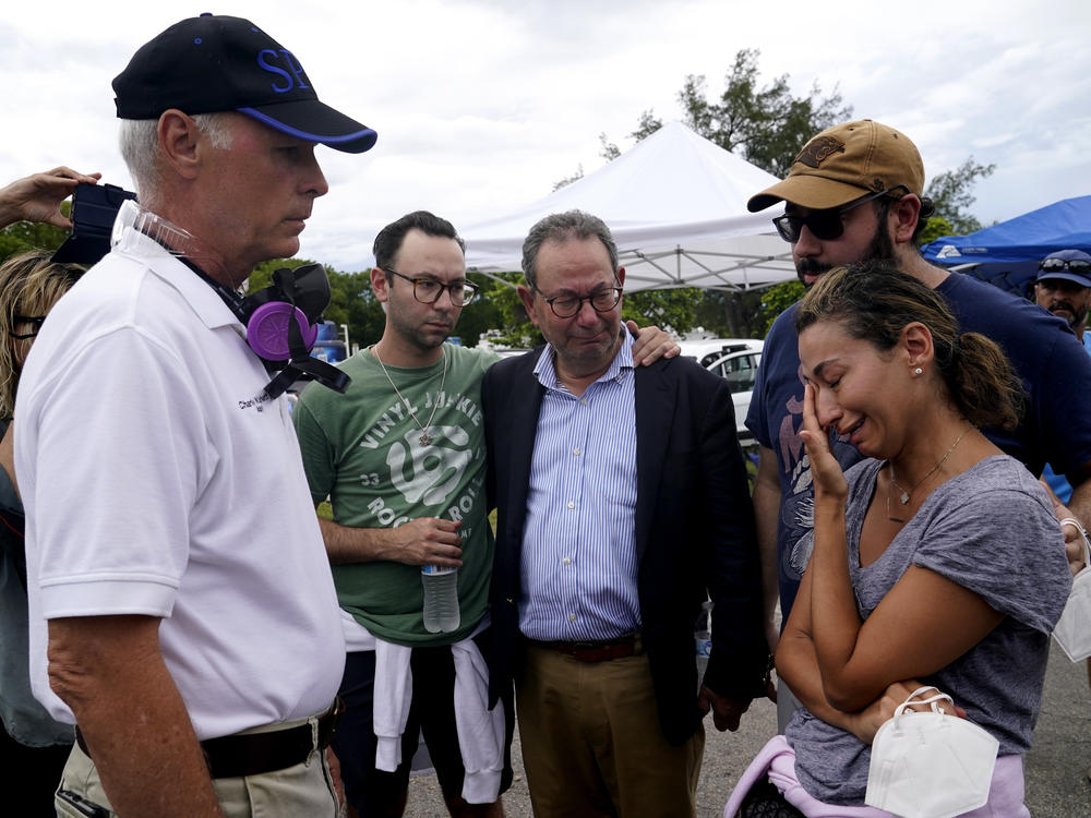 Surfside, Fla., Mayor Charles Burkett (left) talks with Rachel Spiegel, whose mother is missing in the Champlain Towers South collapse.