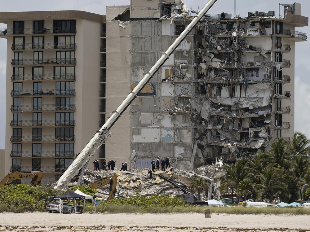 Members of the South Florida Urban Search and Rescue team look for survivors in the partially collapsed 12-story Champlain Towers South condo building in Surfside, Fla., on June 26.