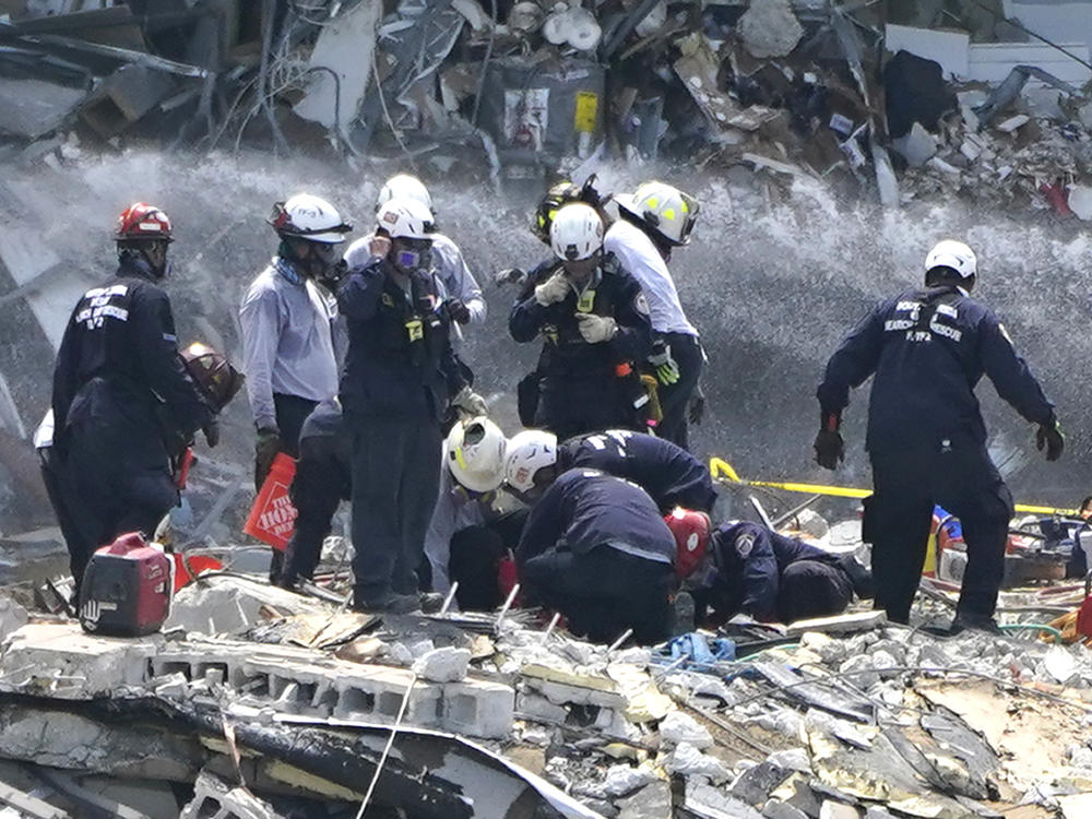 Rescue workers search the rubble of the Champlain Towers South condominium, Saturday. Search and rescue teams found another victim buried underneath the rubble on Tuesday, bringing the death toll to 12.
