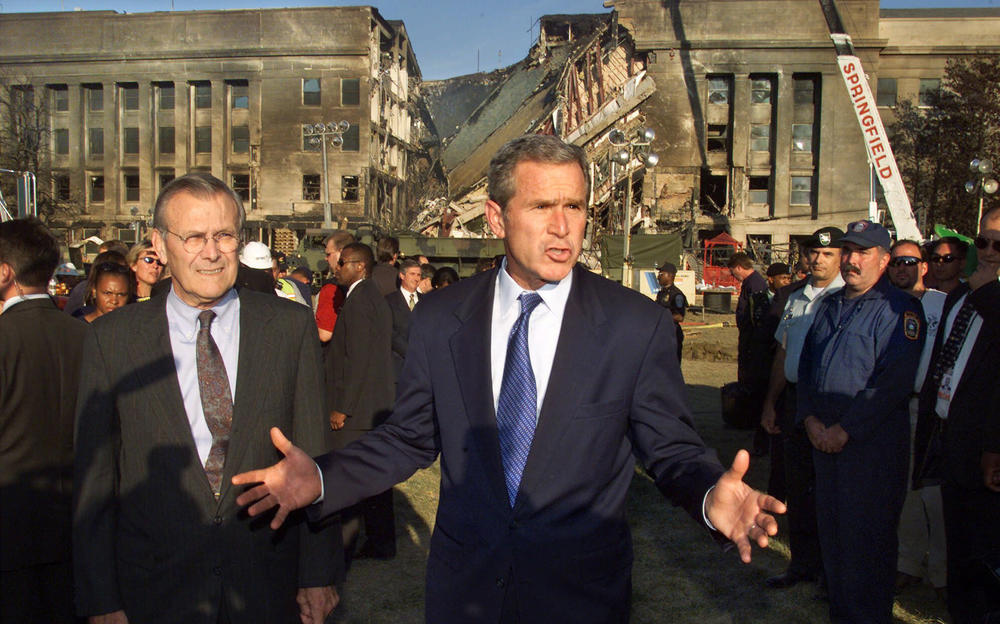 Then-Secretary of Defense Donald Rumsfeld watches as then-President George W. Bush talks about the devastation at the Pentagon on Sept. 12, 2001.