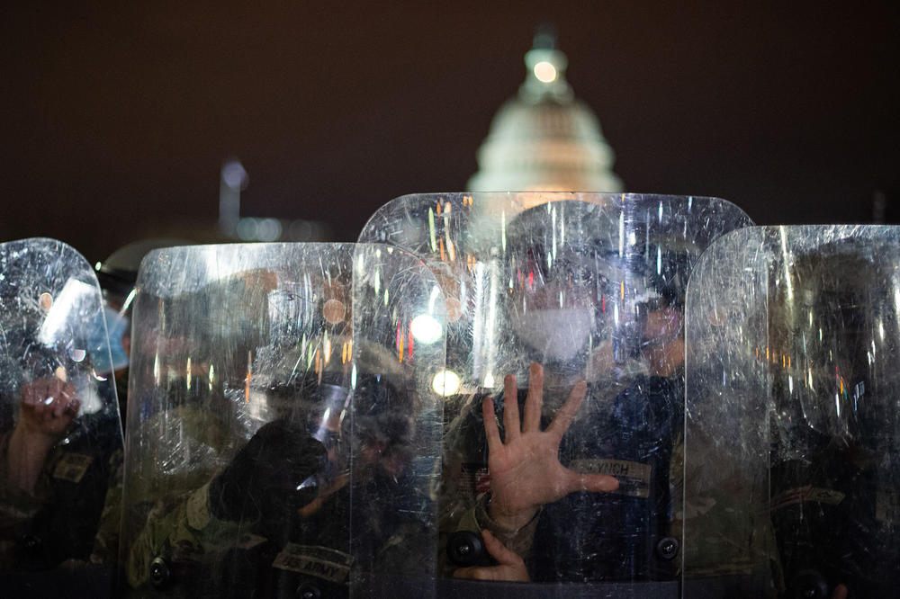 National Guard troops stand behind shields as they clear a street from protesters outside the U.S. Capitol on Jan. 6.