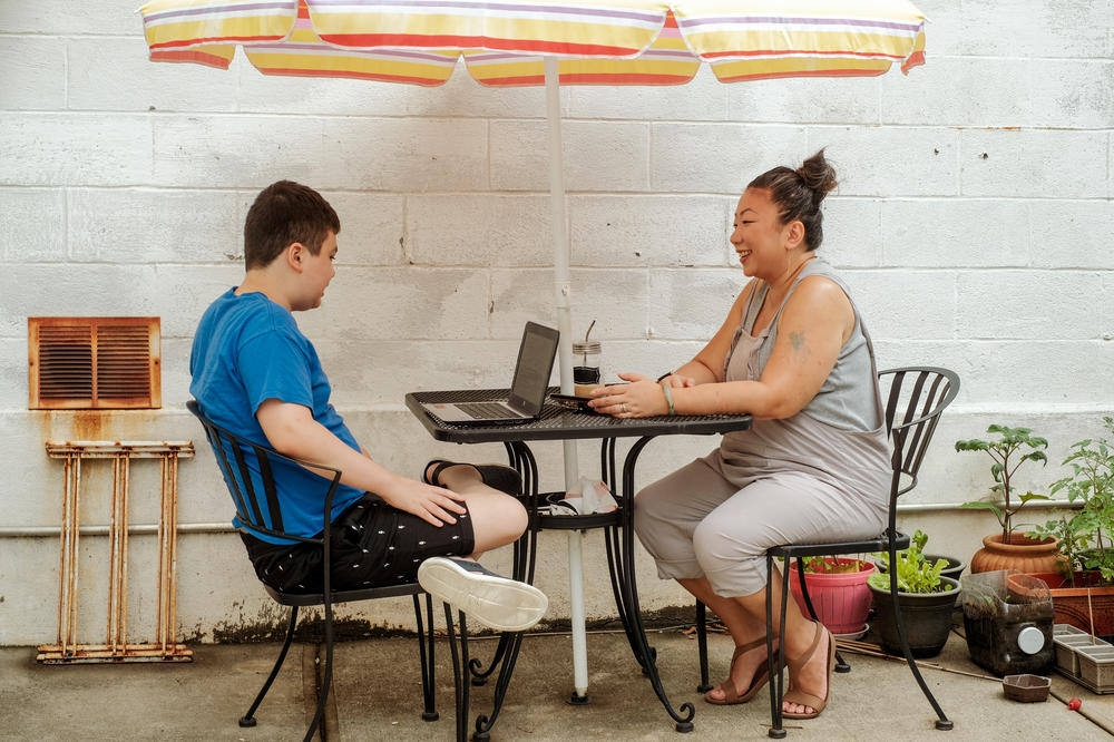 Healy sits with her 13-year-old son, Lucas, in their Brooklyn backyard while he receives remote instruction.