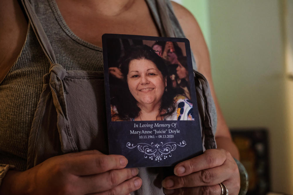 Paullette Healy holds a memorial photo of her aunt MaryAnne Doyle, who died from COVID-19 in August 2020.