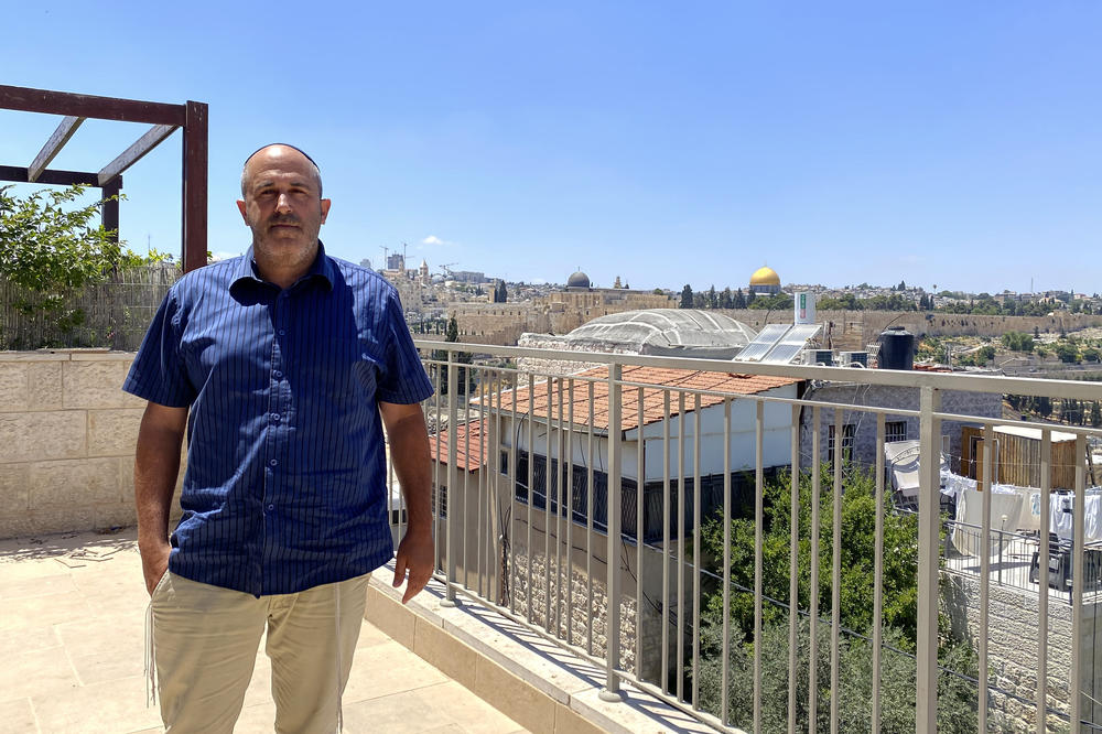 Deputy Jerusalem Mayor Aryeh King stands on his balcony, with the Al-Aqsa mosque in the distance. 