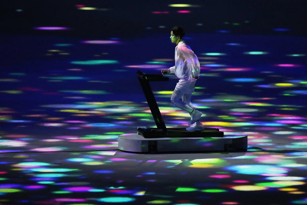 A lone athlete runs during the opening ceremony at the Olympic Stadium on Friday in Tokyo.