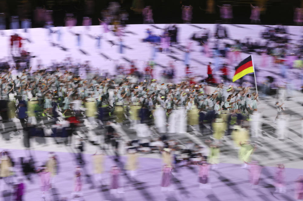 Flag bearers Laura Ludwig and Patrick Hausding of Germany lead their team out during the opening ceremony.