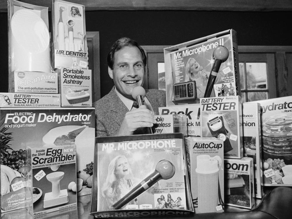 In this 1982 file photo, Ron Popeil, the man behind those late-night, rapid-fire television commercials that sell everything from the Mr. Microphone to the Pocket Fisherman to the classic Veg-a-Matic, sits surrounded by his wares in his office in Beverly Hills, Calif. Popeil died Wednesday, his family said.