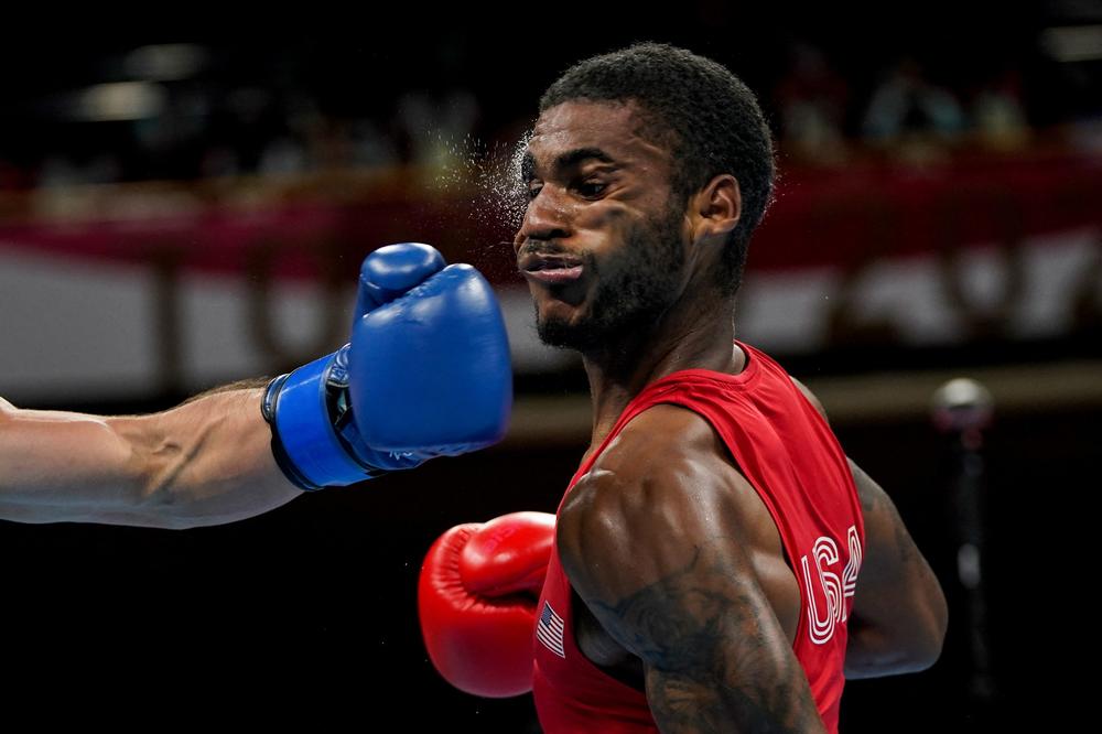 U.S.'s Delante Marquis Johnson takes a punch from Argentina's Brian Agustin Arregui during their men's welter (63-69kg) preliminaries boxing match on July 24, 2021.