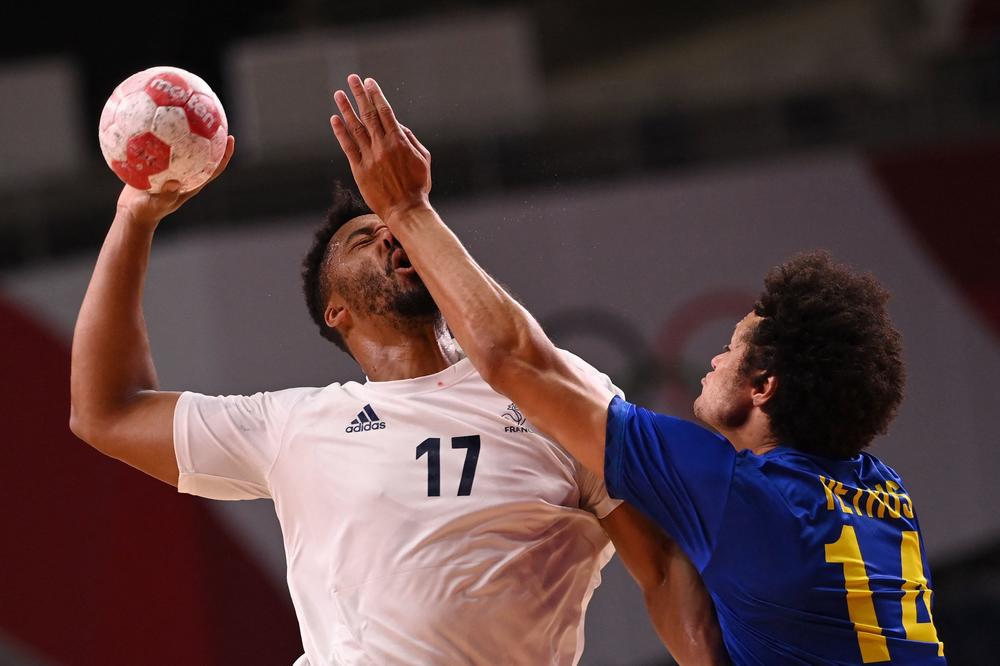 France's left back Timothey N'Guessan, left, is fouled by Brazil's left back Thiagus Petrus during the men's Preliminary Round Group A handball match between Brazil and France on July 26, 2021.