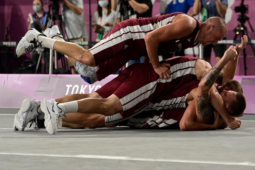 Latvia's teammates celebrate after wining at the end of the men's gold medal 3x3 basketball final match between Russia and Latvia on July 28, 2021.