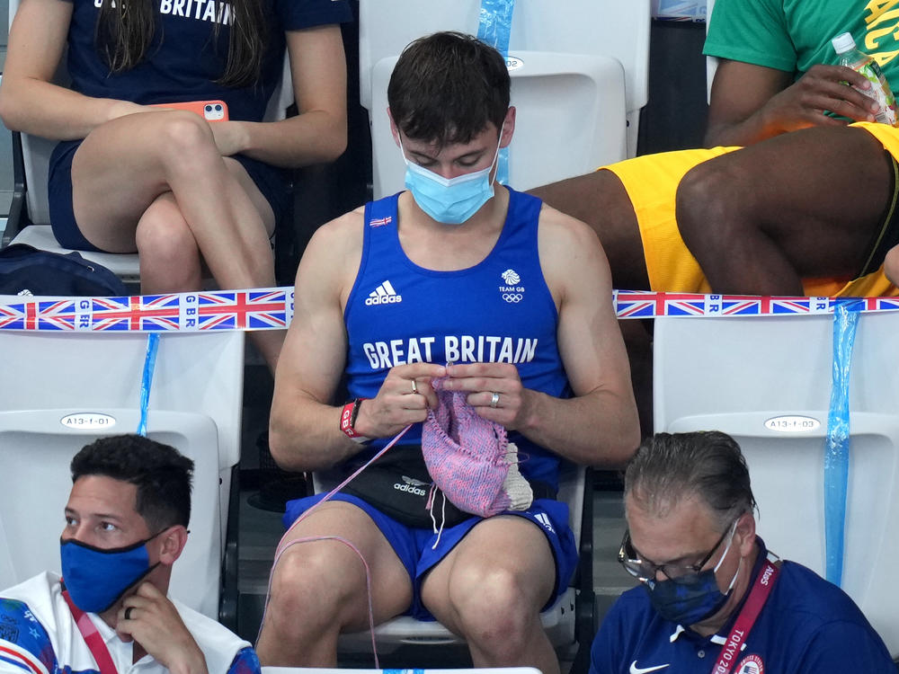 Great Britain's Tom Daley knits in the stands Sunday during the women's 3-meter springboard final at the Tokyo Aquatics Centre at the Olympic Games.