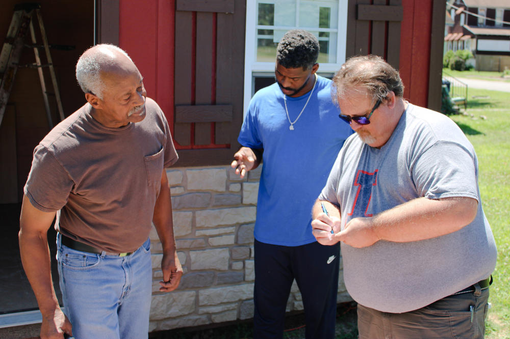 University of Illinois Extension director Jody Johnson (right) exchanges contact information with Lee Wright (left) and son Roman Wright. The extension's office in southern Illinois has launched a vaccination education program that aims to reach this storied city; Johnson knows listening to locals will be key.