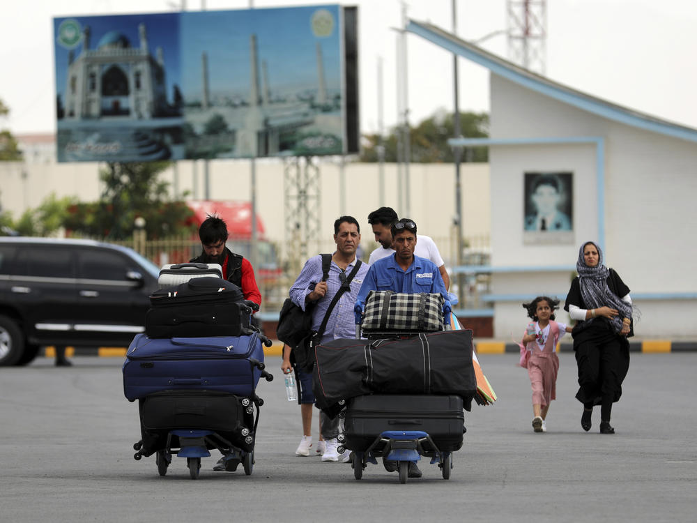 <strong>Sat., Aug. 14:</strong> Passengers walk to the departures terminal of Hamid Karzai International Airport in Kabul.