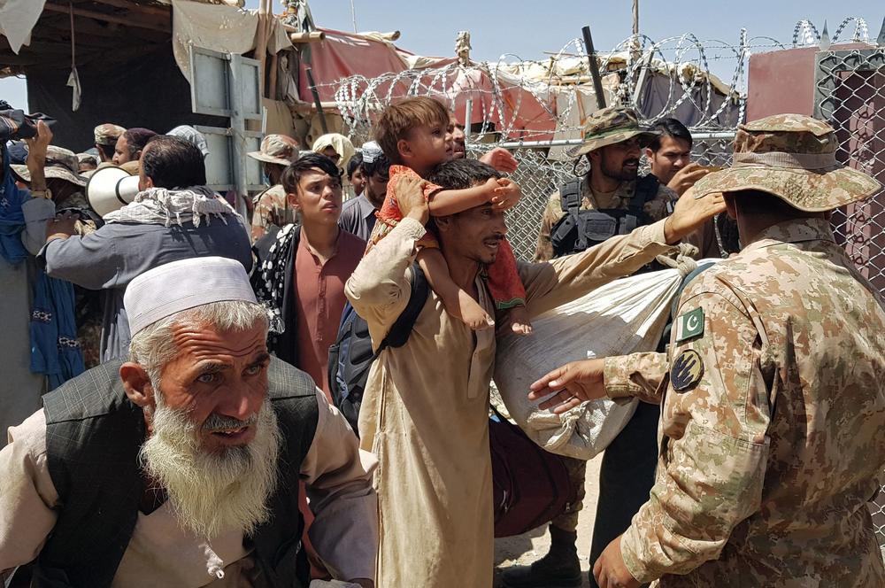 <strong>Fri., Aug. 13:</strong> Pakistani soldiers, right, check stranded Afghan nationals at the Pakistan-Afghanistan border crossing point in Chaman.